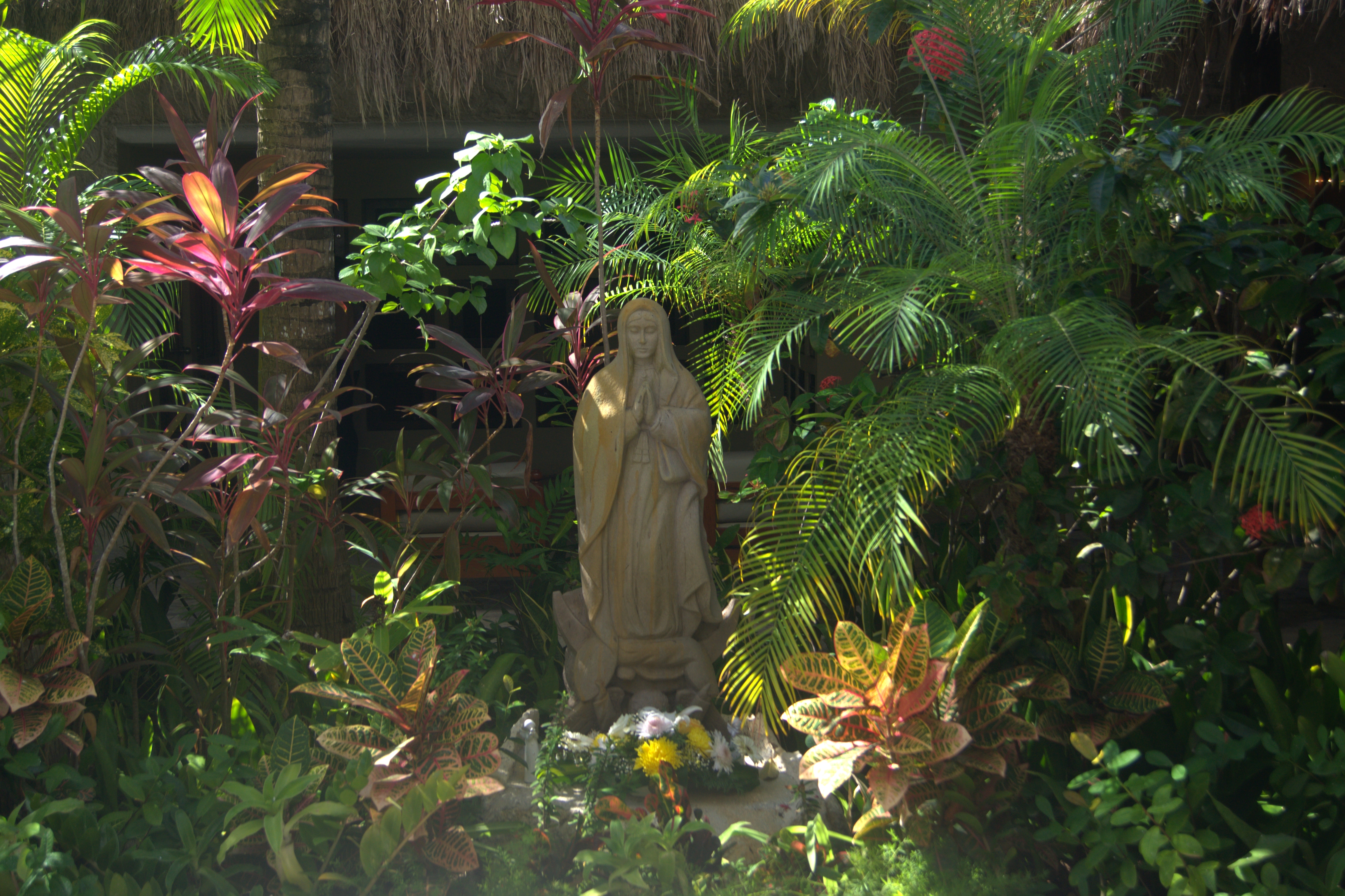 small statue surrounded by flora